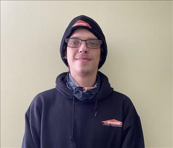 Young man standing with Servpro sweatshirt and hat on