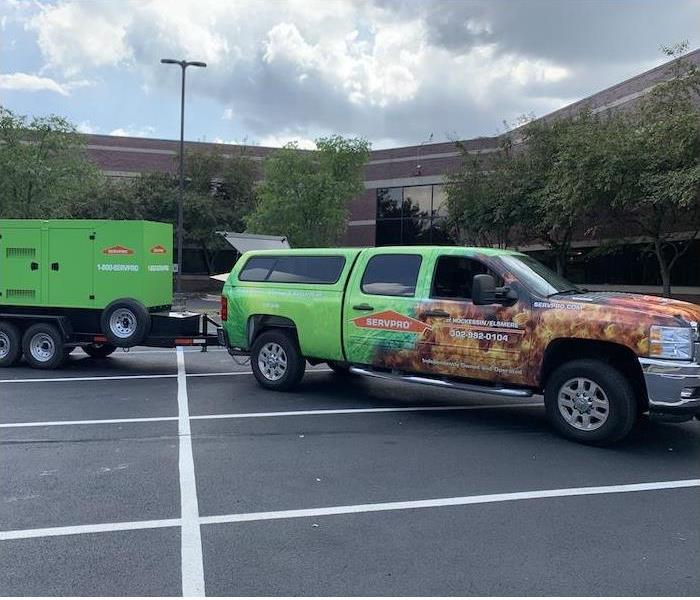 Alt Image: SERVPRO truck in a parking lot towing large equipment