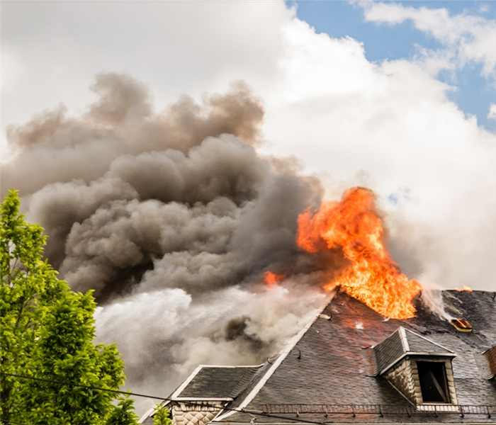 a house on fire with smoke billowing from the roof